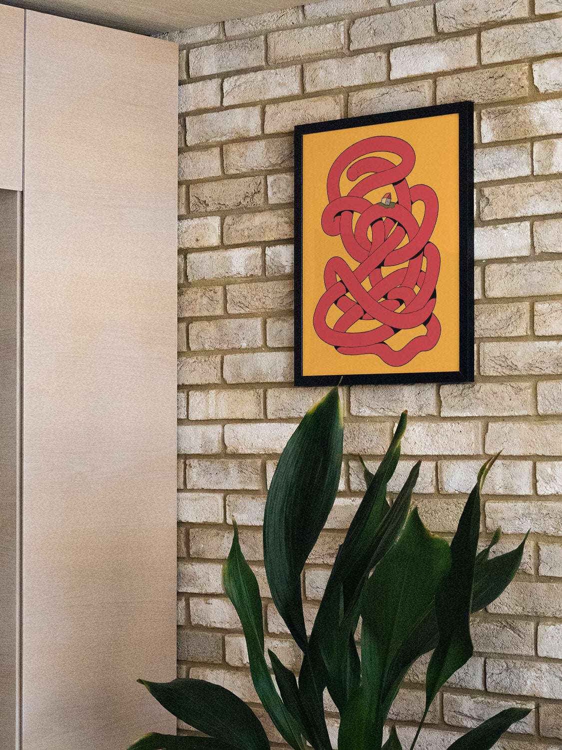 "Noodle" by Ori Toor in black frame displayed in a styled room, showcasing abstract fine art print in an interior setting. |type=lifestyle|