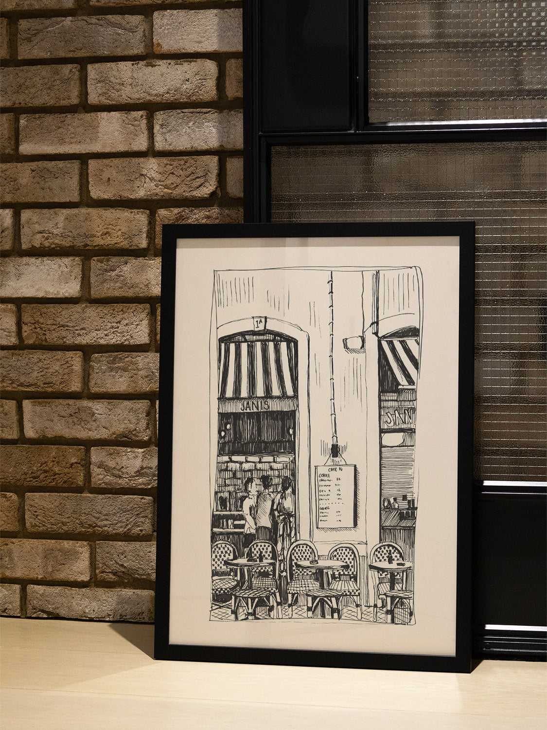 "Cafe Janis" by Emma Louise fine art print in black frame displayed in styled interior. |type=lifestyle|