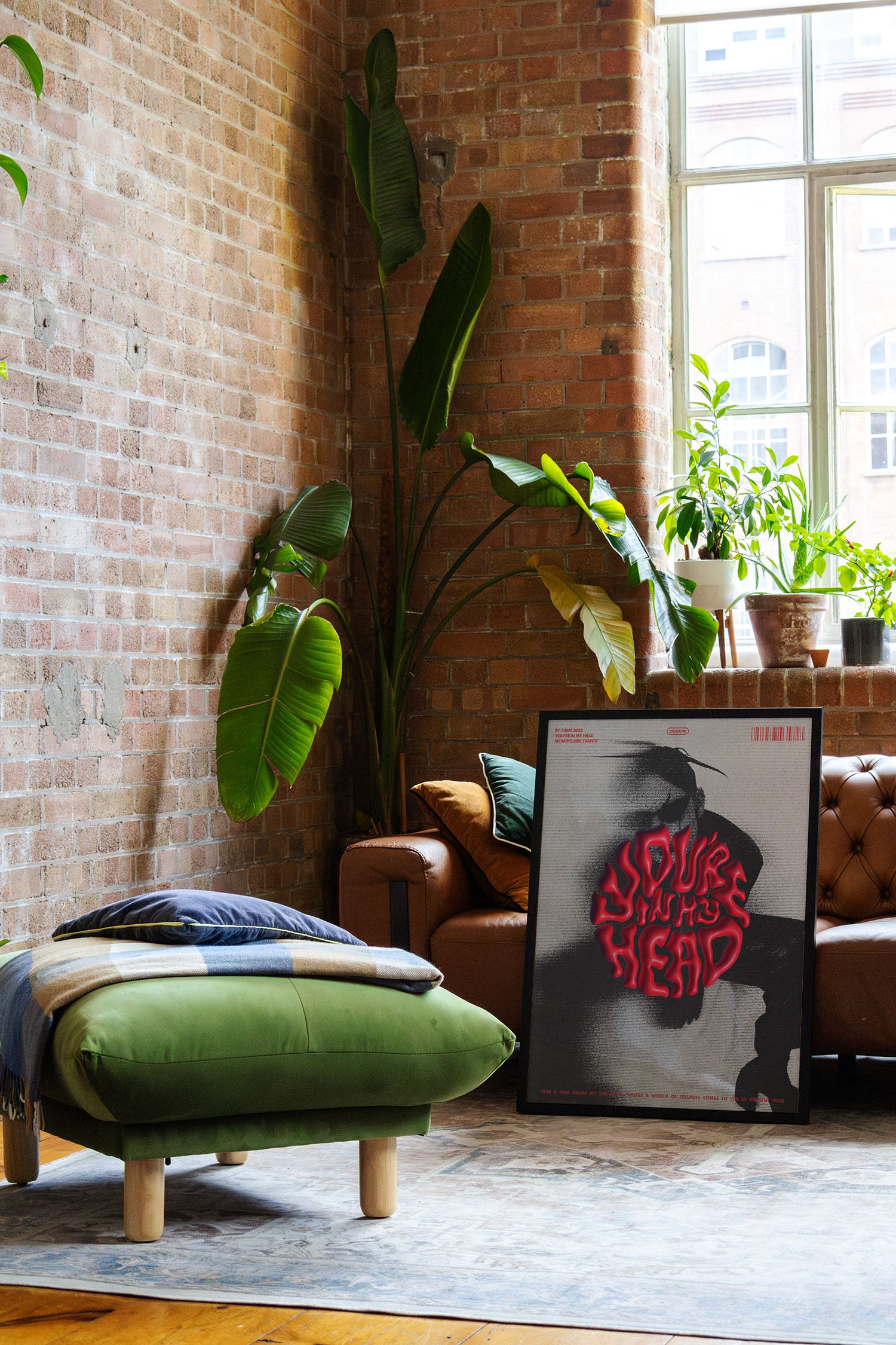 a living room with a brick wall and a painting on the floor