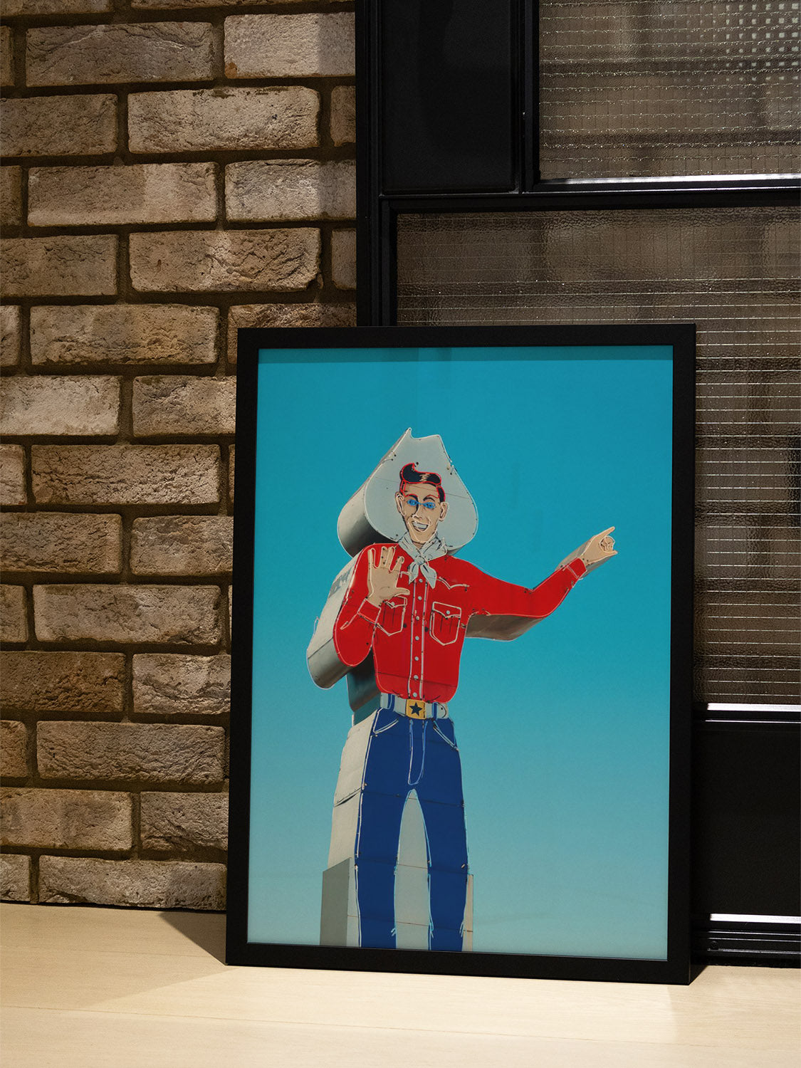 "Head West, Texas" by Philip Jobling in black frame displayed in styled interior setting